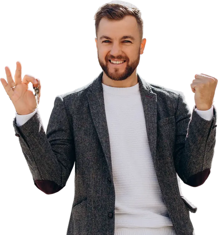 Male real estate professional in a gray blazer giving an "OK" hand gesture and smiling.
