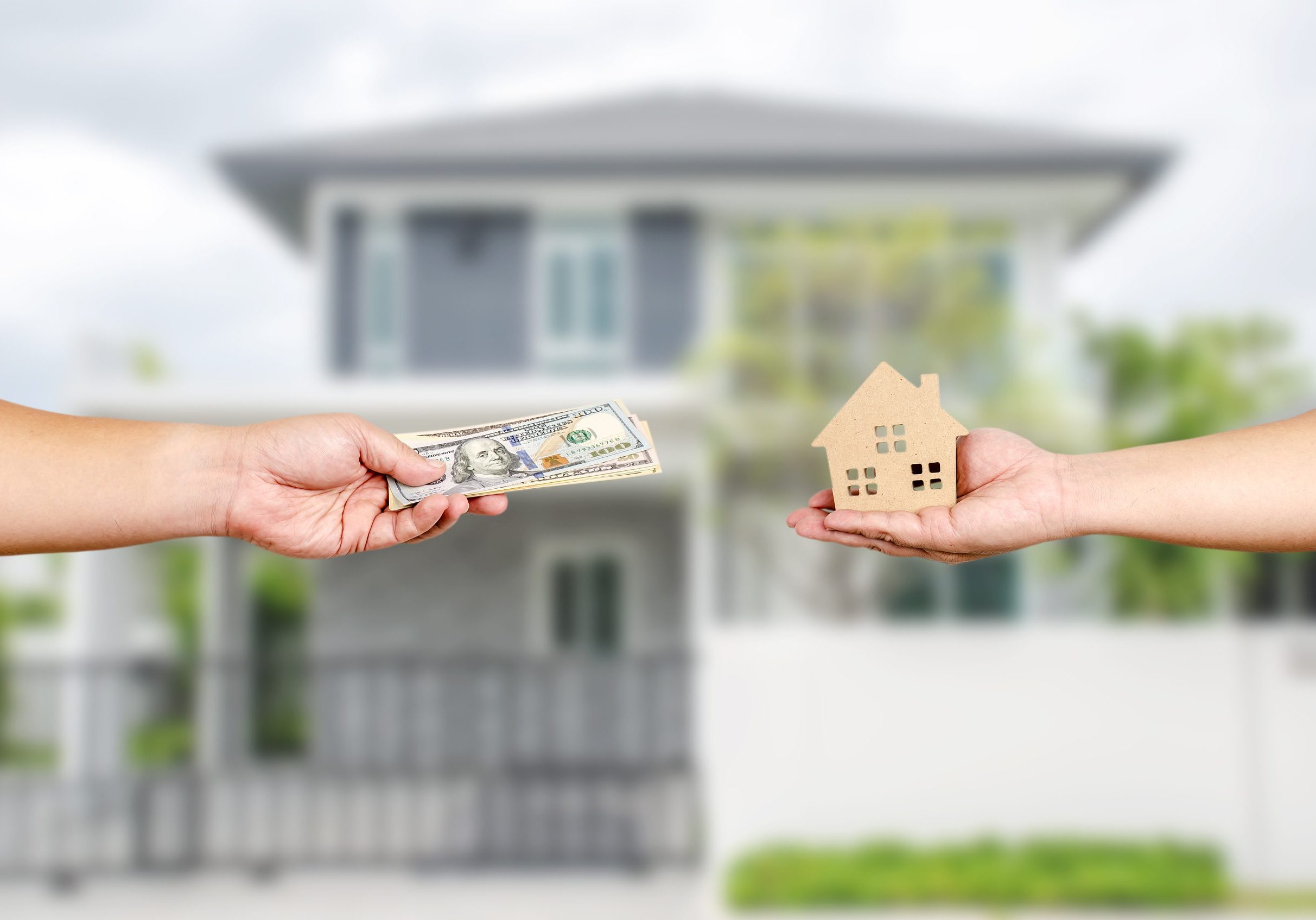 House and money in the hands of investors.Save money for buying a new home and borrowing money to plan the real estate investment in the future on home background. There is space for entering text.