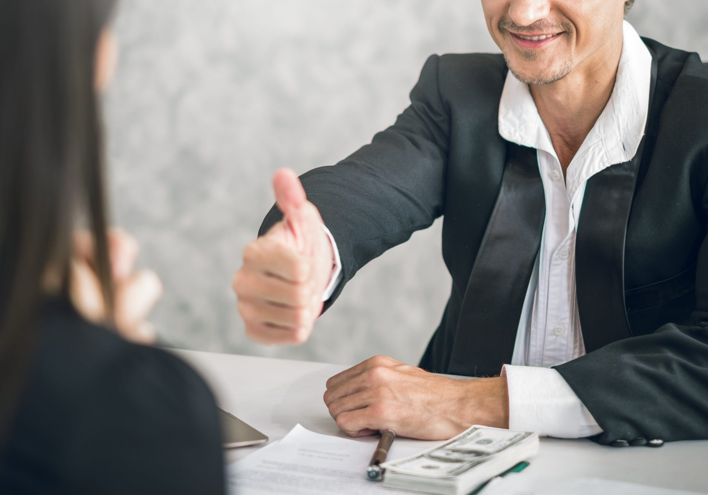 Boss/Business man employer admires young Asian business woman/staff/employee by thumb up and clap with smiling face for her success and good/best in work and recognition/appreciate.