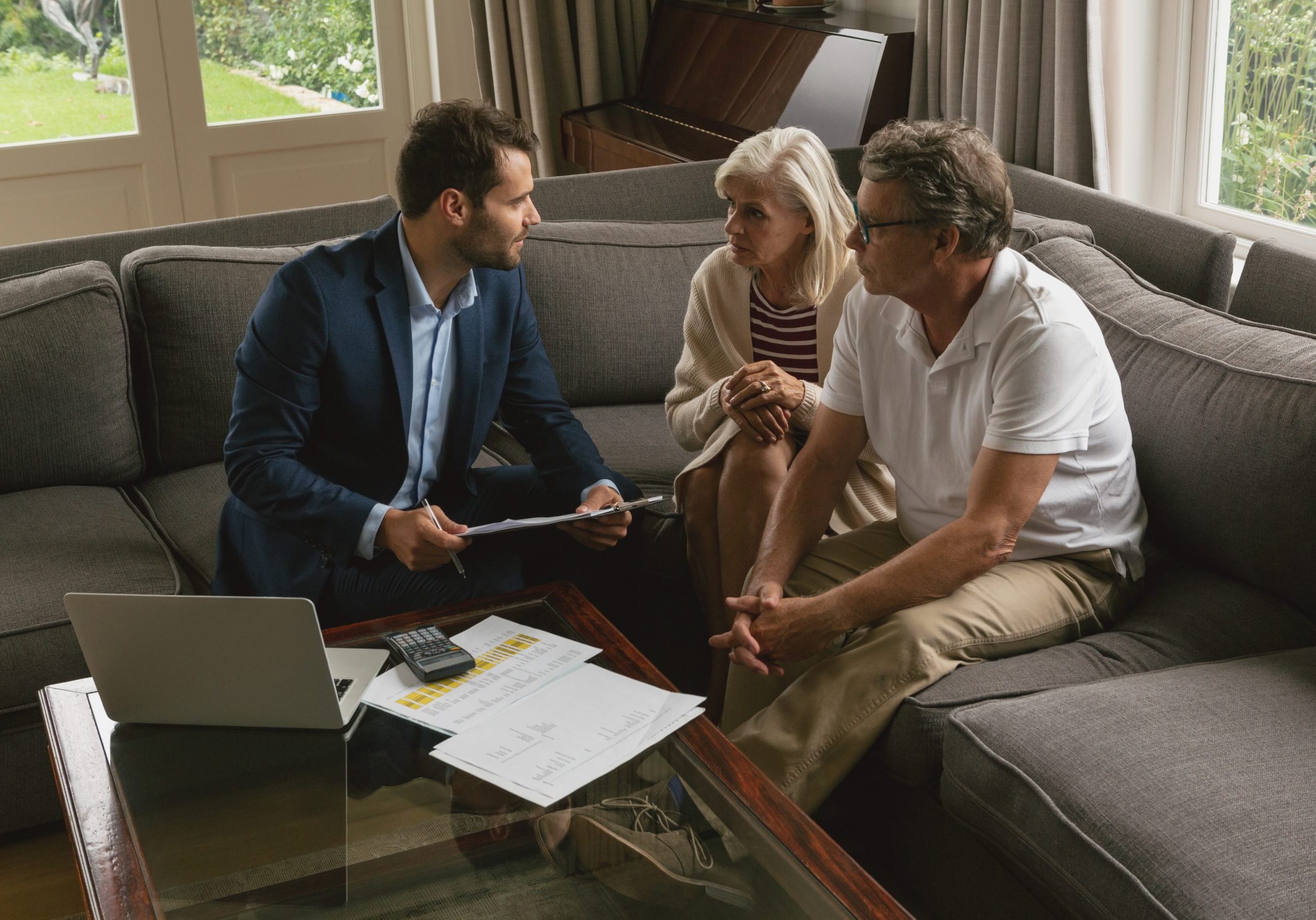 High view of active senior Caucasian couple discussing with real estate agent in living room at home